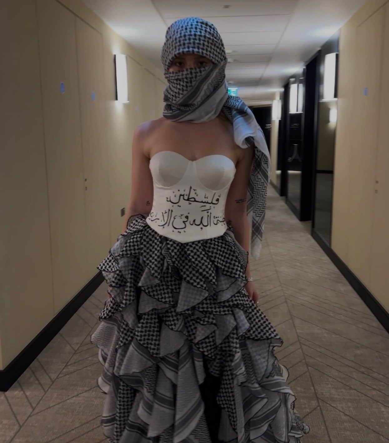 Atelier Qeblawi Calligraphy Gown — front full-length view, white corset bodice with hand-painted Arabic calligraphy over a ruffled black-and-white kufiyeh-fabric gown.